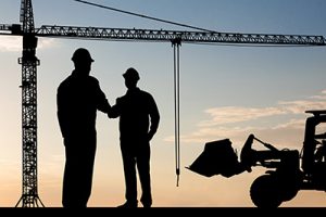 Silhouette Of Two Architect At Construction Site Shaking Hand